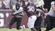 Appalachian State Mountaineers running back Camerun Peoples (6) rushes against Texas A&M Aggies defensive lineman Tunmise Adeleye (30) in the second quarter  at Kyle Field. 
