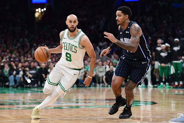 Celtics guard Derrick White controls the ball while Magic guard Jalen Suggs defends.