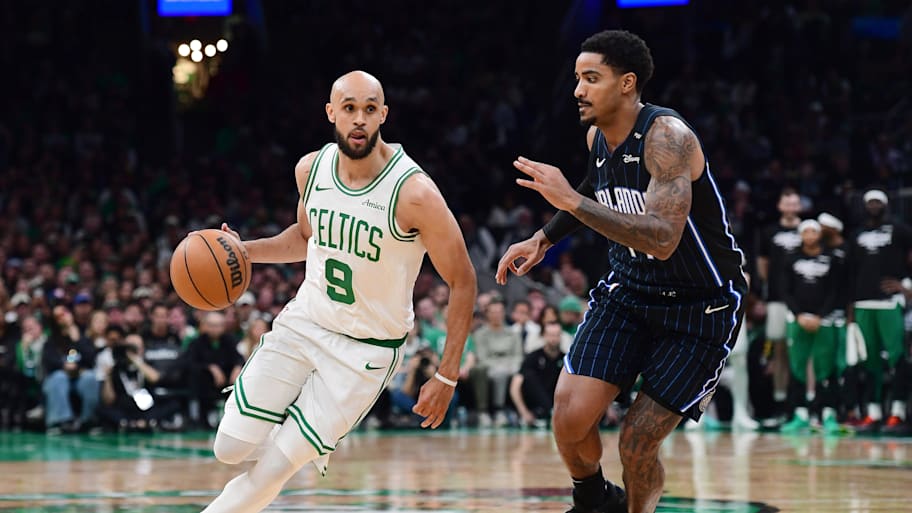 Celtics guard Derrick White controls the ball while Magic guard Jalen Suggs defends.