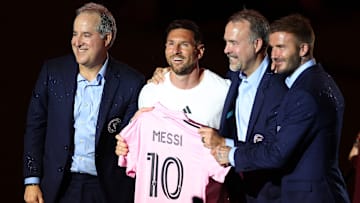 Lionel Messi holds his new Inter Miami CF jersey while club co-owners Jorge Mas, Jose Mas and David Beckham pose with the Herons' new captain in June 2023.