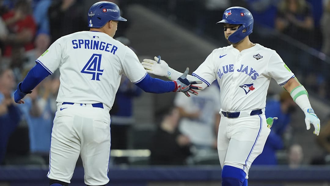 Nov 1, 2025; Toronto, Ontario, CAN; Toronto Blue Jays designated hitter Bo Bichette (11) celebrates with right fielder George Springer (4) after hitting a three run home run against the Los Angeles Dodgers in the third inning during game seven of the 2025 MLB World Series at Rogers Centre. 