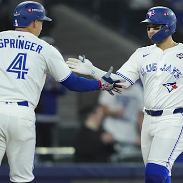 Nov 1, 2025; Toronto, Ontario, CAN; Toronto Blue Jays designated hitter Bo Bichette (11) celebrates with right fielder George Springer (4) after hitting a three run home run against the Los Angeles Dodgers in the third inning during game seven of the 2025 MLB World Series at Rogers Centre. 