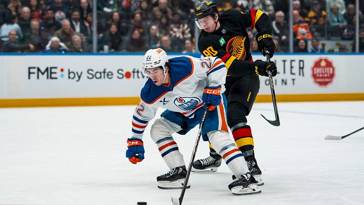 Jan 17, 2026; Vancouver, British Columbia, CAN; Edmonton Oilers forward Matt Savoie (22) drives past Vancouver Canucks defenseman Victor Mancini (90) in the first period at Rogers Arena. Mandatory Credit: Bob Frid-Imagn Images