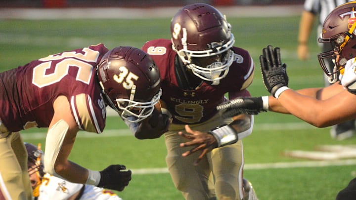 Killingly senior Everton Brown breaks through the line while getting a block from Hunter Allard (35) during Killingly's 32-26 win over Sheehan on Friday at Morgan Field.