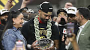 Jun 14, 2025; St. Louis, MO, USA; UFL Owner Dany Garcia presents DC Defenders quarterback Jordan Ta'amu with  the UFL Championship MVP trophy after the DC Defenders defeat the Michigan Panthers 2025 UFL Championship game at The Dome at America’s Center. Mandatory Credit: Jeff Le-Imagn Images