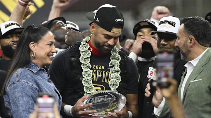 Jun 14, 2025; St. Louis, MO, USA; UFL Owner Dany Garcia presents DC Defenders quarterback Jordan Ta'amu with  the UFL Championship MVP trophy after the DC Defenders defeat the Michigan Panthers 2025 UFL Championship game at The Dome at America’s Center. Mandatory Credit: Jeff Le-Imagn Images