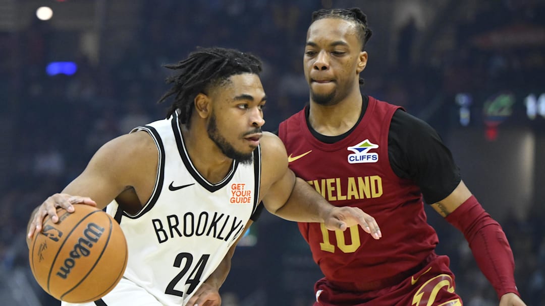Mar 11, 2025; Cleveland, OH; Cam Thomas drives past Cavs guard Darius Garland at Rocket Arena. 