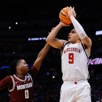 Mar 20, 2025; Denver, CO, USA; Wisconsin Badgers guard John Tonje (9) shoots the ball against Montana Grizzlies guard Money Williams (0) during the first half in the first round of the NCAA Tournament at Ball Arena. Mandatory Credit: Isaiah J. Downing-Imagn Images