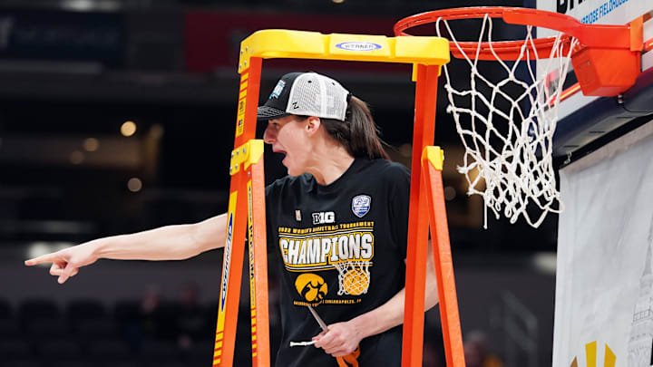Mar 6, 2022; Indianapolis, IN, USA;  Iowa Hawkeyes guard Caitlin Clark (22) celebrates after cutting a piece of the net after defeating Indiana in the Big Ten conference tournament championship game between Iowa and Indiana at Gainbridge Fieldhouse. Mandatory Credit: Robert Goddin-Imagn Images