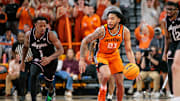 Nov 9, 2025; Stillwater, Oklahoma, USA; Oklahoma State Cowboys guard Isaiah Coleman (21) brings the ball up court around Texas A&M Aggies guard Josh Holloway (1) during the first half at Gallagher-Iba Arena. Mandatory Credit: William Purnell-Imagn Images