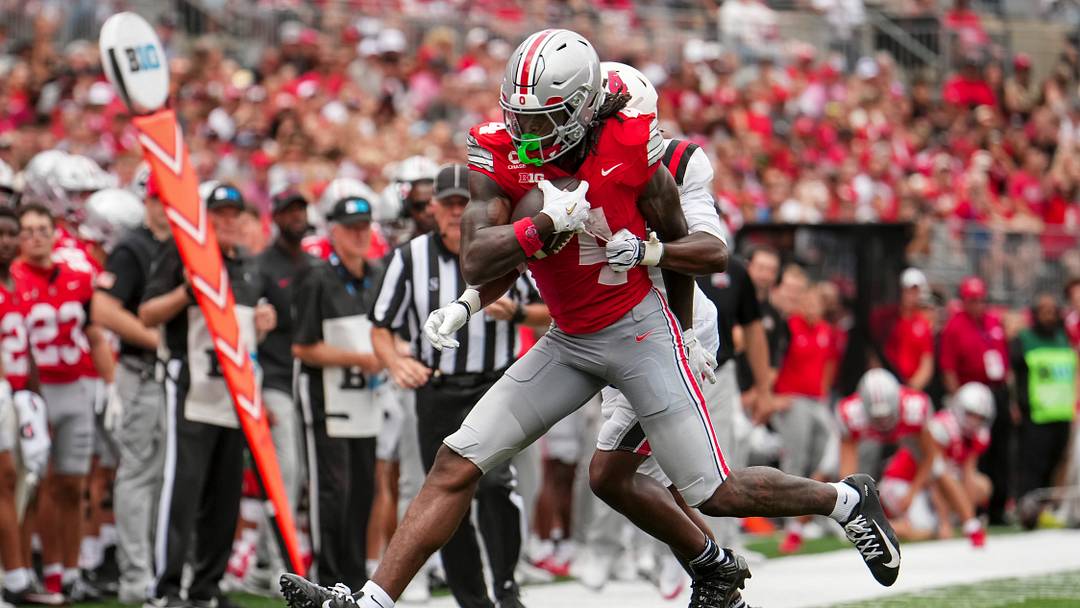 Ohio State Buckeyes wide receiver Jeremiah Smith (4) catches a pass in front of Ball State Cardinals defensive back Willizhuan Yates (4) during the NCAA football game at Ohio Stadium in Columbus on Sept. 5, 2026.