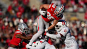 Ohio State Buckeyes tight end Max Klare (86) leaps over Rutgers Scarlet Knights linebacker Dariel Djabome (8) and defensive back Kaj Sanders (5) during the NCAA football game at Ohio Stadium in Columbus on Nov. 22, 2025. Ohio State won 42-9.