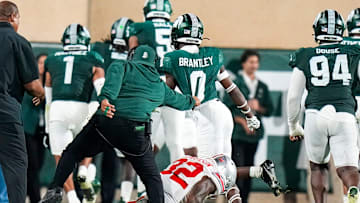 Sep 28, 2024; East Lansing, Michigan, USA; Michigan State Spartans defensive back Charles Brantley (0) is pulled after stepping over Ohio State Buckeyes running back TreVeyon Henderson (32) in the first half at Spartan Stadium on Saturday.