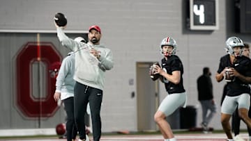 Ohio State Buckeyes head coach Ryan Day throws alongside quarterbacks Julian Sayin (10) and Tavien St. Clair (9) during spring football practice at the Woody Hayes Athletic Center in Columbus on March 19, 2025.