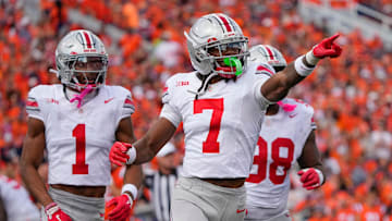 Ohio State Buckeyes cornerback Jermaine Mathews Jr. (7), cornerback Davison Igbinosun (1) and defensive lineman Kayden McDonald (98) celebrate after a fumble by Illinois Fighting Illini quarterback Luke Altmyer (9) during the second half of the NCAA football game at Gies Memorial Stadium in Champaign on Oct. 11, 2025. Ohio State won 34-16.