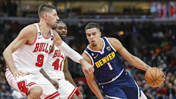 Oct 7, 2022; Chicago, Illinois, USA; Denver Nuggets forward Michael Porter Jr. (1) drives to the basket against Chicago Bulls center Nikola Vucevic (9) during the second half at United Center. Mandatory Credit: Kamil Krzaczynski-Imagn Images