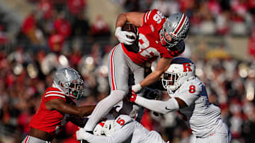 Ohio State Buckeyes tight end Max Klare (86) leaps over Rutgers Scarlet Knights linebacker Dariel Djabome (8) and defensive back Kaj Sanders (5) during the NCAA football game at Ohio Stadium in Columbus on Nov. 22, 2025. Ohio State won 42-9.