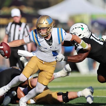 Aug 31, 2024; Honolulu, Hawaii, USA; UCLA Bruins quarterback Ethan Garbers (4) scrambles away from Hawaii Rainbow Warriors defensive lineman Dion Washington (19) during the fourth quarter of an NCAA college football game at the Clarence T.C. Ching Athletics Complex. Mandatory Credit: Marco Garcia-Imagn Images