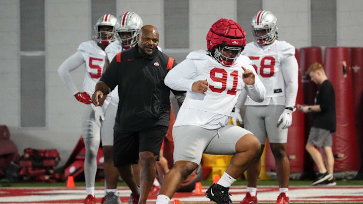 Defensive lineman Tyleik Williams runs drills under the watchful eye of his position coach Larry Johnson.