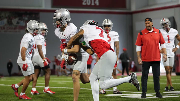 Mar 7, 2024; Columbus, OH, USA; Ohio State Buckeyes cornerback Jordan Hancock (7) tries to strip a ball from Ohio State Buckeyes cornerback Aaron Scott Jr. (5) during spring football practice at the Woody Hayes Athletic Center.