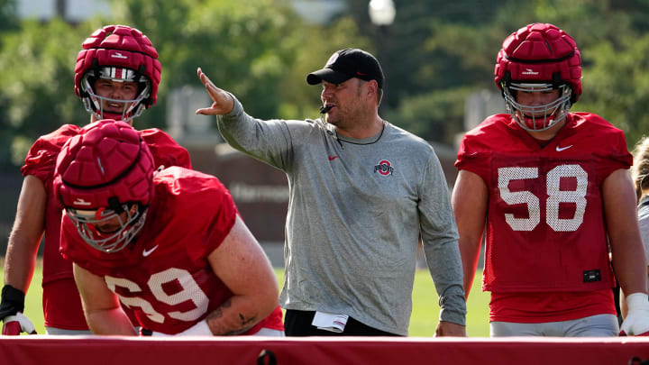 Aug 1, 2024; Columbus, OH, USA; Ohio State Buckeyes offensive line coach Justin Frye motions to his players during football camp at the Woody Hayes Athletic Complex.