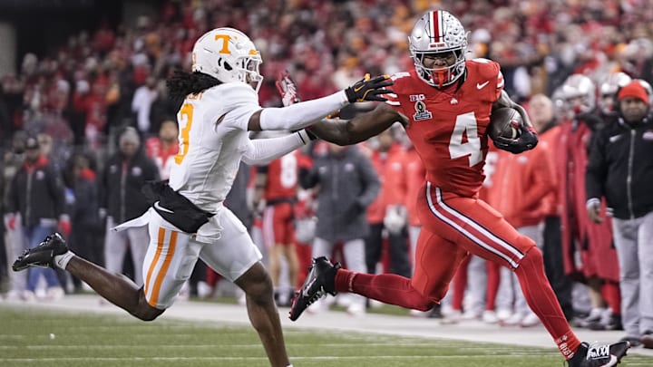 Ohio State Buckeyes wide receiver Jeremiah Smith (4) runs past Tennessee Volunteers defensive back Jermod McCoy (3) during the first half of the College Football Playoff first round game at Ohio Stadium in Columbus on Dec. 21, 2024.