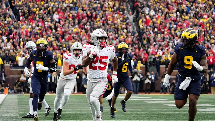 Ohio State Buckeyes running back Bo Jackson (25) runs past Michigan Wolverines defensive end Cameron Brandt (9) during the NCAA football game at Michigan Stadium in Ann Arbor, Mich. on Nov. 29, 2025. Ohio State won 27-9.