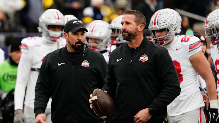 Ohio State Buckeyes offensive coordinator Brian Hartline and head coach Ryan Day leads warm ups during the NCAA football game against the Michigan Wolverines at Michigan Stadium in Ann Arbor, Mich. on Nov. 29, 2025. Ohio State won 27-9.