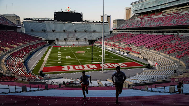 Brutus Buckeye team members Kurt Steelman, left, and Caleb Kies run steps inside Ohio Stadium at the start of an early morning conditioning workout on Aug. 25, 2025.