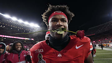 Ohio State Buckeyes safety Caleb Downs leaves the field with a rose in his mouth following the 42-17 win over the Tennessee Volunteers in the College Football Playoff first round game at Ohio Stadium in Columbus on Dec. 21, 2024. Ohio State will face Oregon in the Rose Bowl.