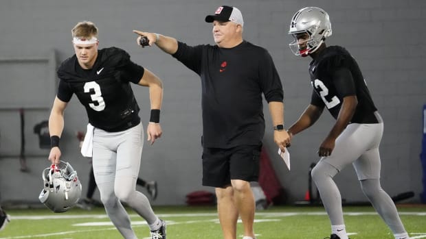 Ohio State Buckeyes offensive coordinator Chip Kelly works with quarterbacks Lincoln Kienholz (3) and Air Noland (12) during 