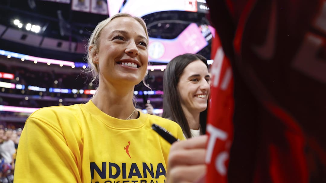 Jul 27, 2025; Chicago, Illinois, USA; Indiana Fever guards Sophie Cunningham (8) and Caitlin Clark (22)sign autographs before a WNBA game against the Chicago Sky at United Center. Mandatory Credit: Kamil Krzaczynski-Imagn Images