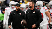 Ohio State Buckeyes offensive coordinator Brian Hartline and head coach Ryan Day leads warm ups during the NCAA football game against the Michigan Wolverines at Michigan Stadium in Ann Arbor, Mich. on Nov. 29, 2025. Ohio State won 27-9.