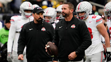 Ohio State Buckeyes offensive coordinator Brian Hartline and head coach Ryan Day leads warm ups during the NCAA football game against the Michigan Wolverines at Michigan Stadium in Ann Arbor, Mich. on Nov. 29, 2025. Ohio State won 27-9.