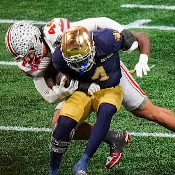 Ohio State Buckeyes defensive end JT Tuimoloau (44) tackles Notre Dame Fighting Irish running back Jeremiyah Love (4) during the College Football Playoff championship at Mercedes-Benz Stadium in Atlanta on Jan. 20, 2025.