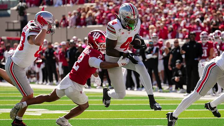 Ohio State Buckeyes wide receiver Jeremiah Smith (4) jumps past Indiana Hoosiers defensive back Byron Baldwin Jr. (2) after making a catch during the NCAA football game at Memorial Stadium Stadium in Bloomington, Ind. on Oct. 17, 2026.