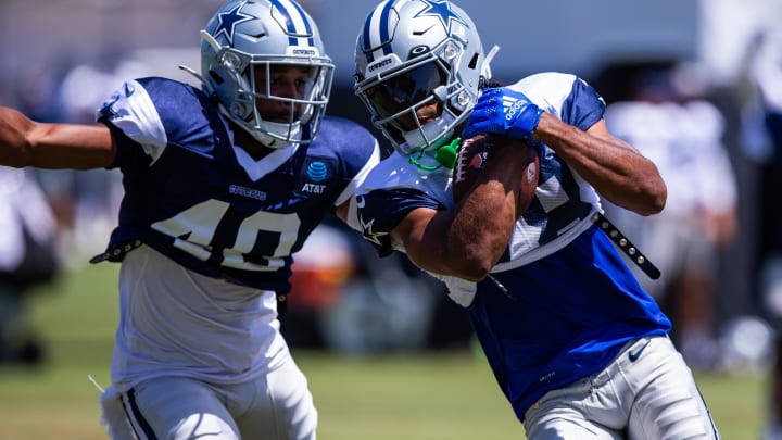 Oxnard, CA, USA; Dallas Cowboys wide receiver Jalen Tolbert (18) keeps the ball from safety Juanyeh Thomas (40) during training camp at Marriott Residence Inn-River Ridge playing fields. 