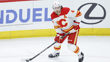 Jan 13, 2025; Chicago, Illinois, USA; Calgary Flames defenseman Rasmus Andersson (4) looks to pass the puck against the Chicago Blackhawks during the second period at United Center. Mandatory Credit: Kamil Krzaczynski-Imagn Images