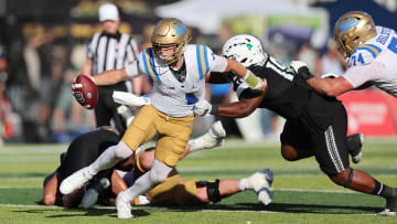 Aug 31, 2024; Honolulu, Hawaii, USA; UCLA Bruins quarterback Ethan Garbers (4) scrambles away from Hawaii Rainbow Warriors defensive lineman Dion Washington (19) during the fourth quarter of an NCAA college football game at the Clarence T.C. Ching Athletics Complex. Mandatory Credit: Marco Garcia-USA TODAY Sports