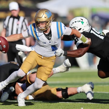 Aug 31, 2024; Honolulu, Hawaii, USA; UCLA Bruins quarterback Ethan Garbers (4) scrambles away from Hawaii Rainbow Warriors defensive lineman Dion Washington (19) during the fourth quarter of an NCAA college football game at the Clarence T.C. Ching Athletics Complex. Mandatory Credit: Marco Garcia-USA TODAY Sports