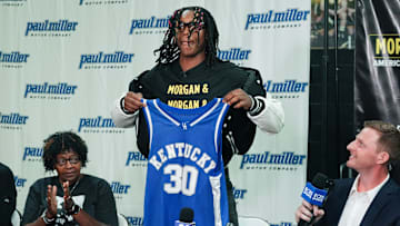 Jasper Johnson, a Lexington native and one of the top basketball players in the 2025 high school class, announces his commitment to the University of Kentucky during a ceremony at the Woodford County High School in Versailles, Ky. on Sep. 5, 2024. His grandmother Rosetta Johnson was at left and 247Sports analyst Travis Branham was at right.