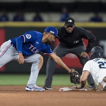 Jun 15, 2024; Seattle, Washington, USA; Seattle Mariners first baseman Tyler Locklear (20) steals second base ahead of a tag by Texas Rangers second baseman Marcus Semien (2) during the sixth inning at T-Mobile Park. 