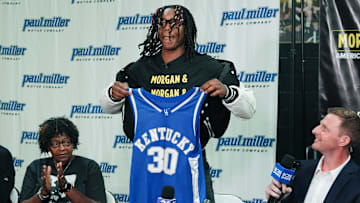 Jasper Johnson, a Lexington native and one of the top basketball players in the 2025 high school class, announces his commitment to the University of Kentucky during a ceremony at the Woodford County High School in Versailles, Ky. on Sep. 5, 2024. His grandmother Rosetta Johnson was at left and 247Sports analyst Travis Branham was at right.