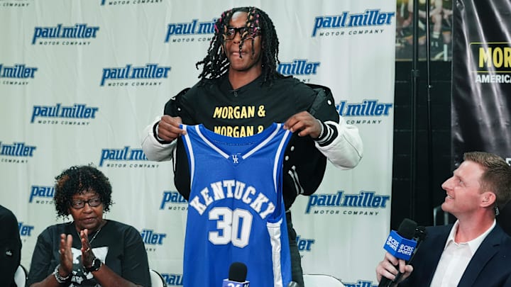 Jasper Johnson, a Lexington native and one of the top basketball players in the 2025 high school class, announces his commitment to the University of Kentucky during a ceremony at the Woodford County High School in Versailles, Ky. on Sep. 5, 2024. His grandmother Rosetta Johnson was at left and 247Sports analyst Travis Branham was at right.