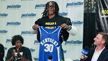 Jasper Johnson, a Lexington native and one of the top basketball players in the 2025 high school class, announces his commitment to the University of Kentucky during a ceremony at the Woodford County High School in Versailles, Ky. on Sep. 5, 2024. His grandmother Rosetta Johnson was at left and 247Sports analyst Travis Branham was at right.