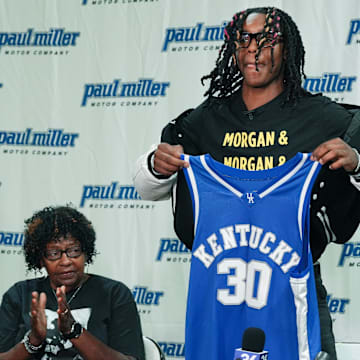 Jasper Johnson, a Lexington native and one of the top basketball players in the 2025 high school class, announces his commitment to the University of Kentucky during a ceremony at the Woodford County High School in Versailles, Ky. on Sep. 5, 2024. His grandmother Rosetta Johnson was at left and 247Sports analyst Travis Branham was at right.