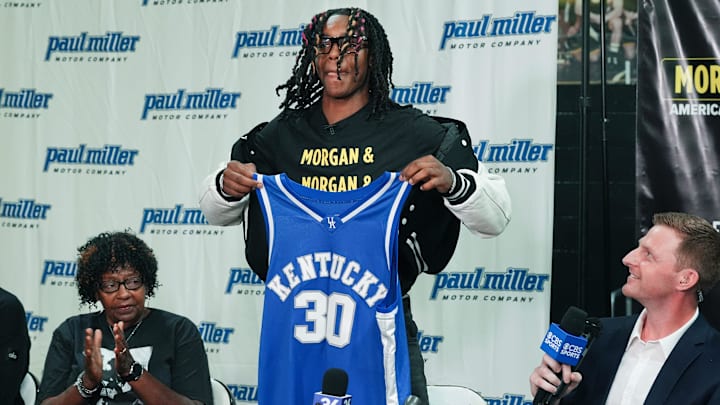 Jasper Johnson, a Lexington native and one of the top basketball players in the 2025 high school class, announces his commitment to the University of Kentucky during a ceremony at the Woodford County High School in Versailles, Ky. on Sep. 5, 2024. His grandmother Rosetta Johnson was at left and 247Sports analyst Travis Branham was at right.