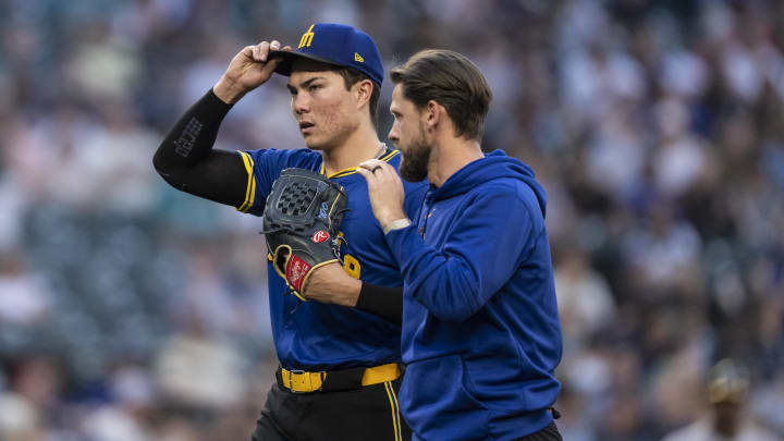 Seattle Mariners starting pitcher Bryan Woo (left) is tended to by a member of the team training staff after leaving a game against the Oakland Athletics in May at T-Mobile Park.