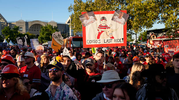 A fan holds up a sign celebrating Lee Corso ahead of Texas-Ohio State.