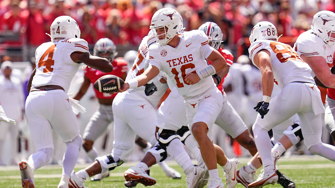 Texas Longhorns quarterback Arch Manning (16) hands off to running back CJ Baxter (4) during the NCAA football game against the Ohio State Buckeyes at Ohio Stadium on Aug. 30, 2025.